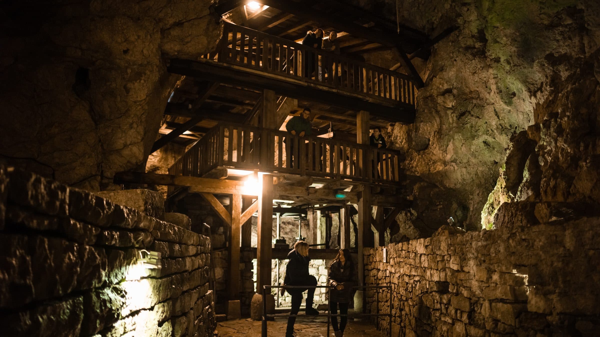 La charpente de bois des Moulins souterrains, éclairée au fond de la grotte du Col-des-Roches.