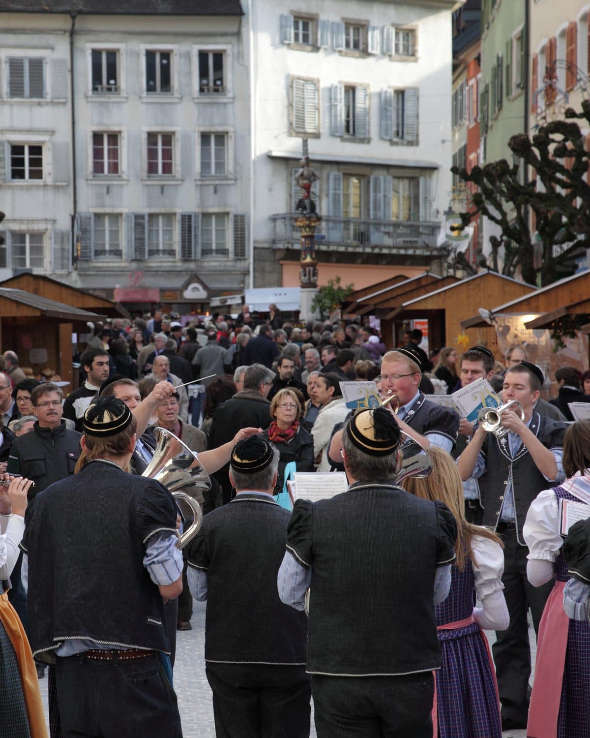 Une fanfare en costume joue au milieu des cabanes du marché de la Saint-Martin, à Porrentruy.