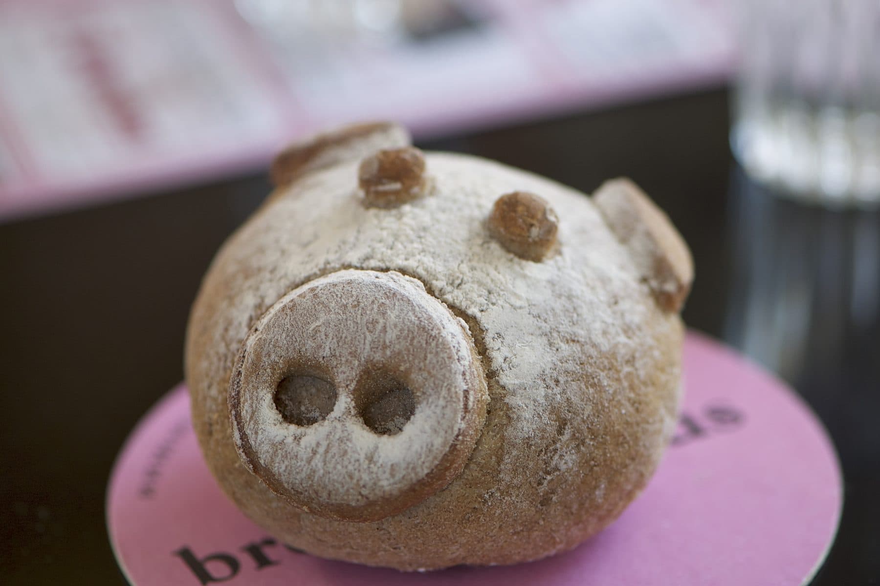 Un petit pain en forme de tête de cochon, posé sur un sous-verre, sur une table de la Saint-Martin.