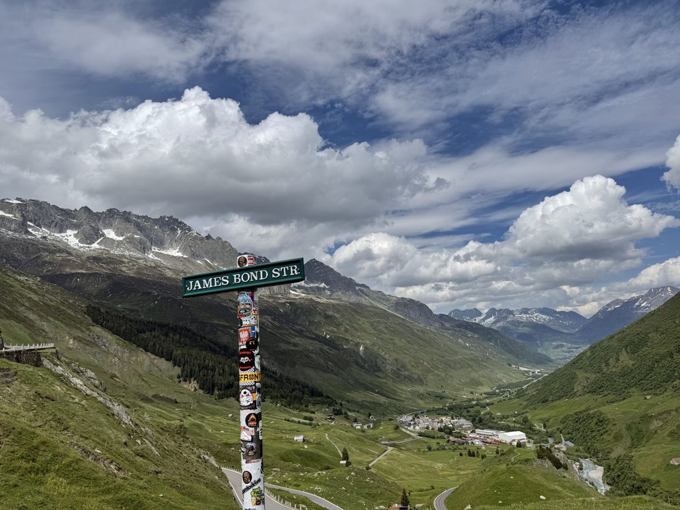 Poteau indicateur au bord de la route du col, la vallée qui descend au loin