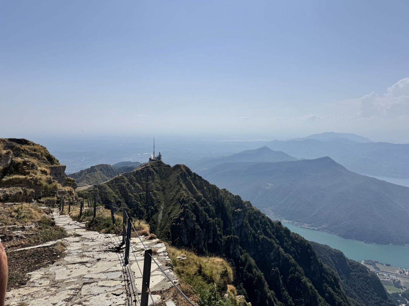 Sentier de crête au-dessus d'un lac, collines boisées en contrebas